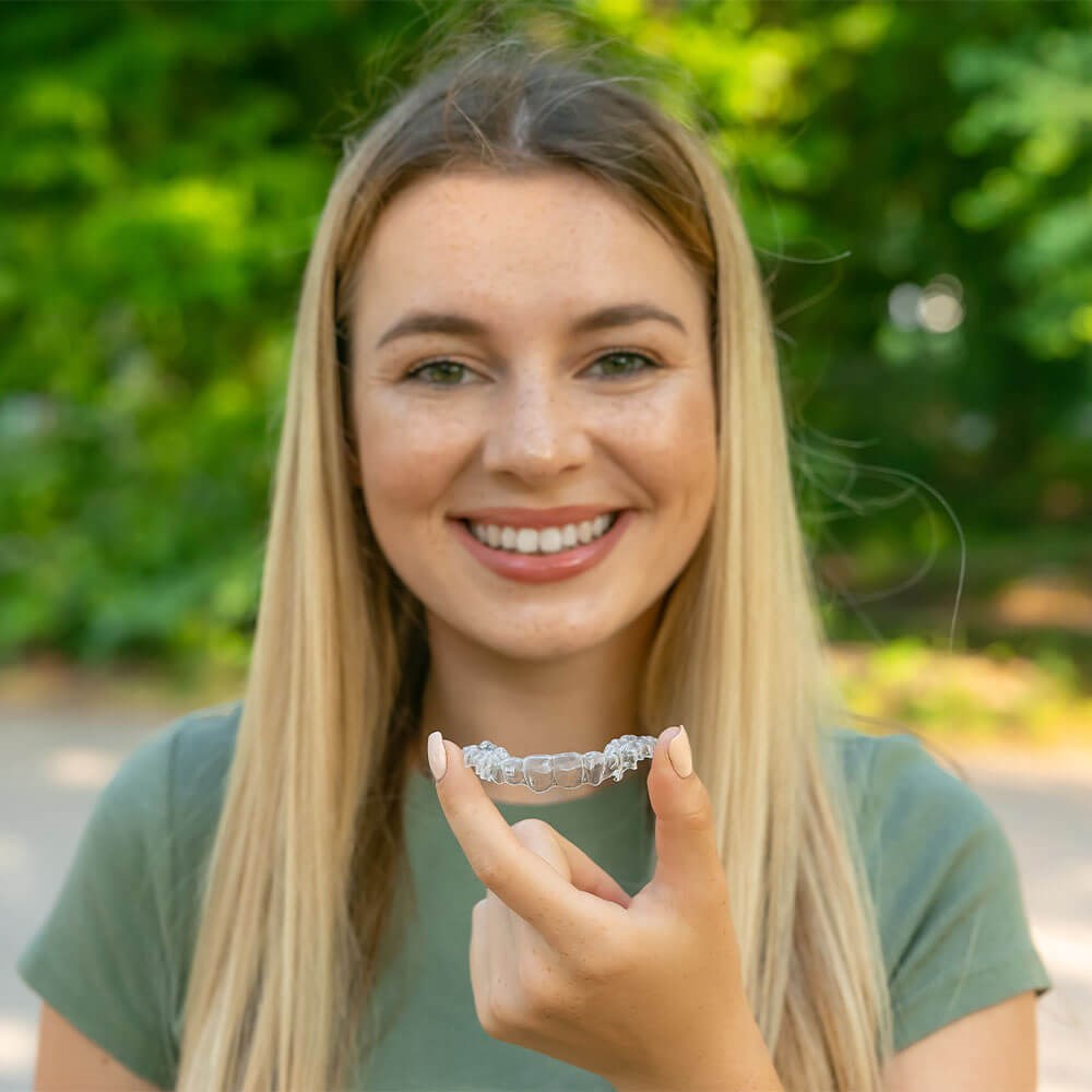 Woman holding clear retainers